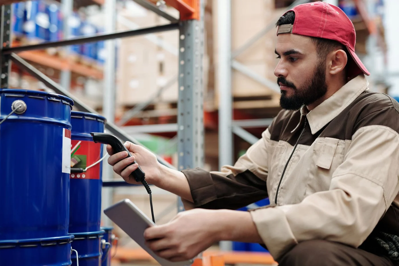A warehouse operator scanning the label on an industrial drum