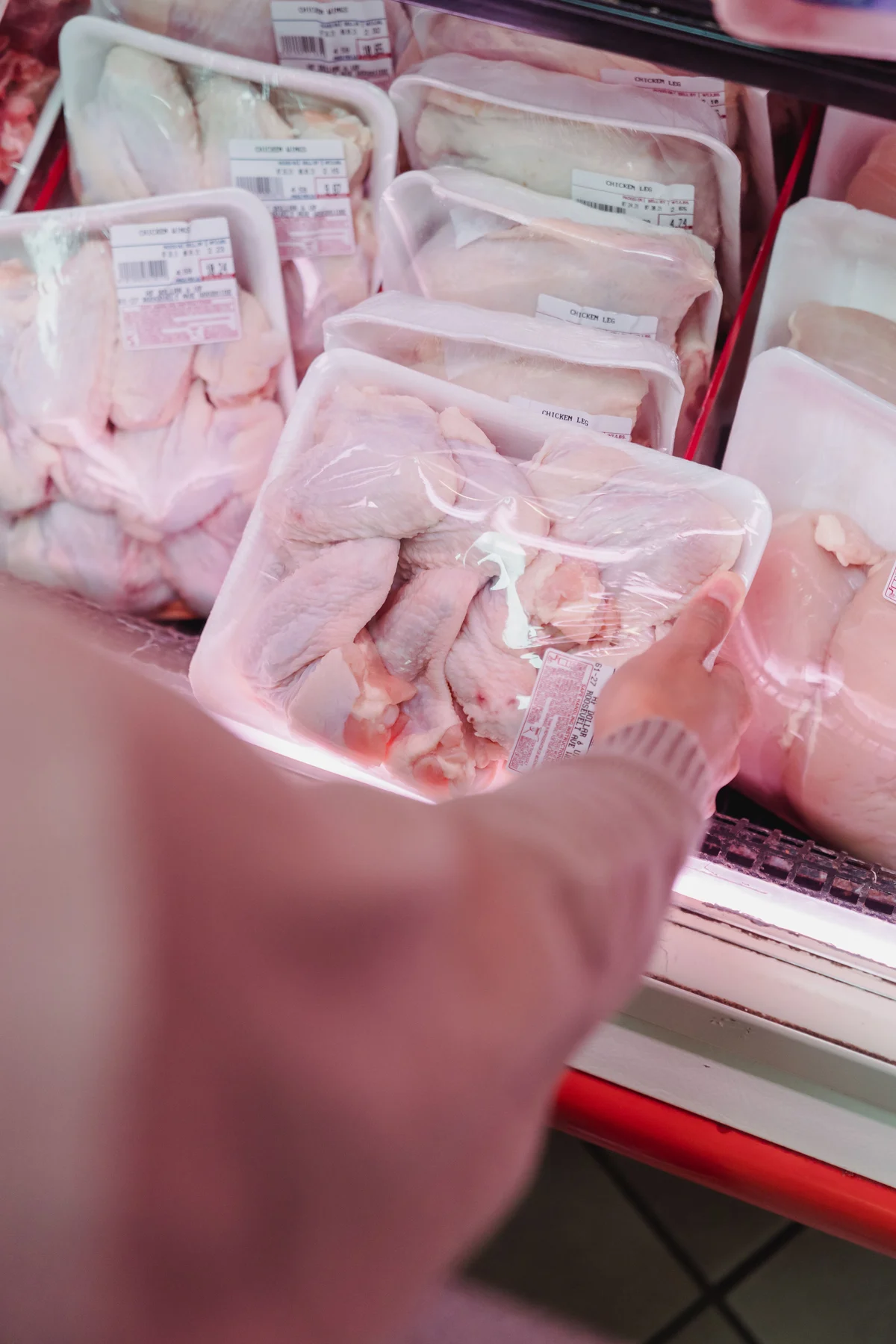 Barcode price labels on wrapped meat trays in a refrigerated display