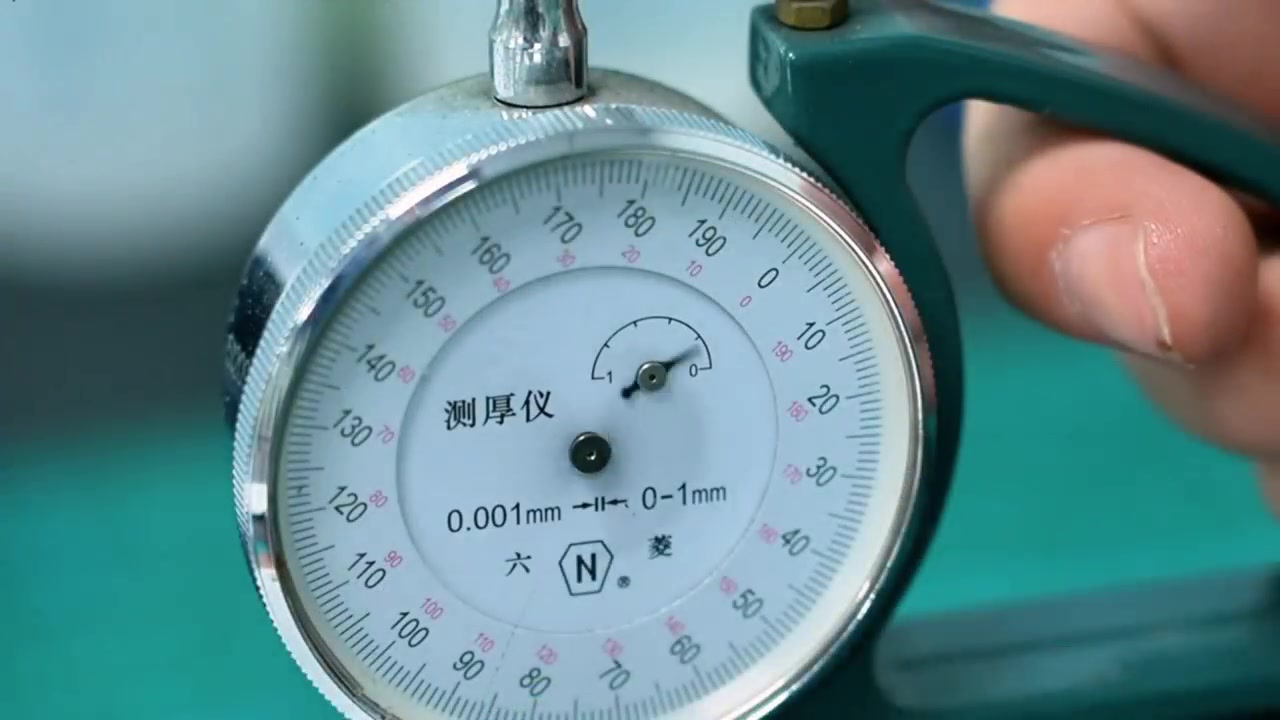 A dial thickness gauge used to check a material sample
